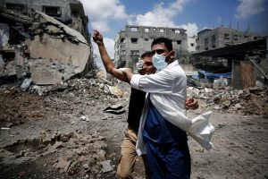 A medic helps a Palestinian in the Shejaia neighbourhood, which was heavily shelled by Israel during fighting, in Gaza City